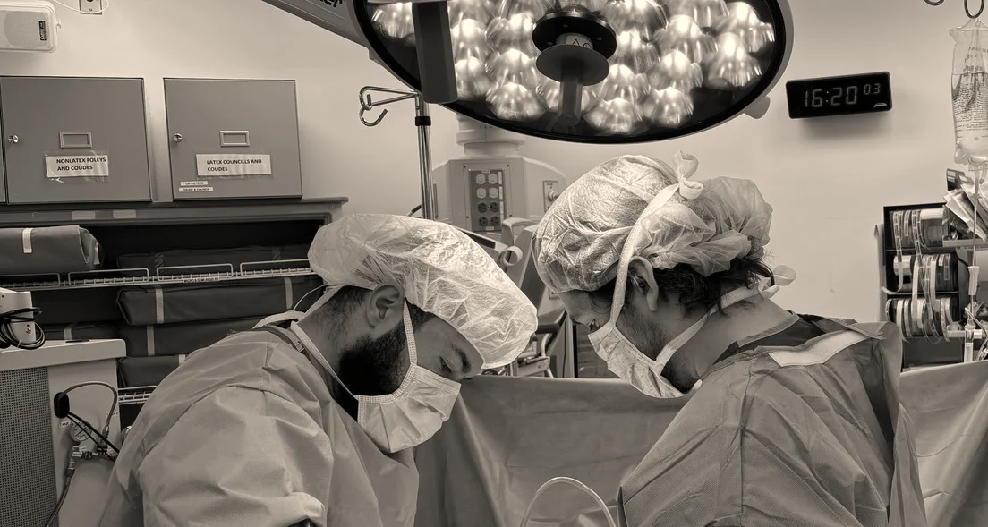 Dr. Jeremy Goodman operating with a colleague under surgical lights